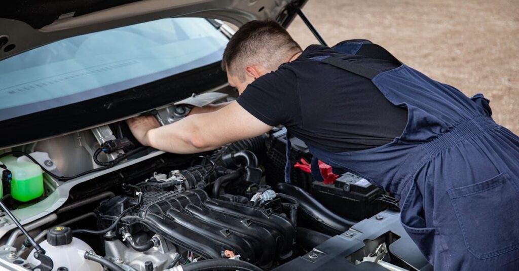 A mechanic in overalls works on a car engine outdoors, showcasing automotive maintenance.